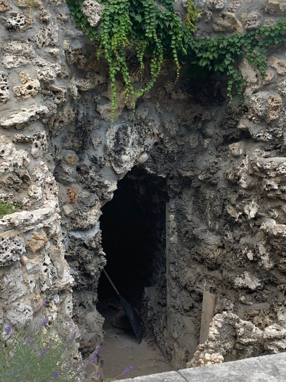 The ornamental 'rocaille' grotto or cave features decorative rock-work, pebbles, and shells